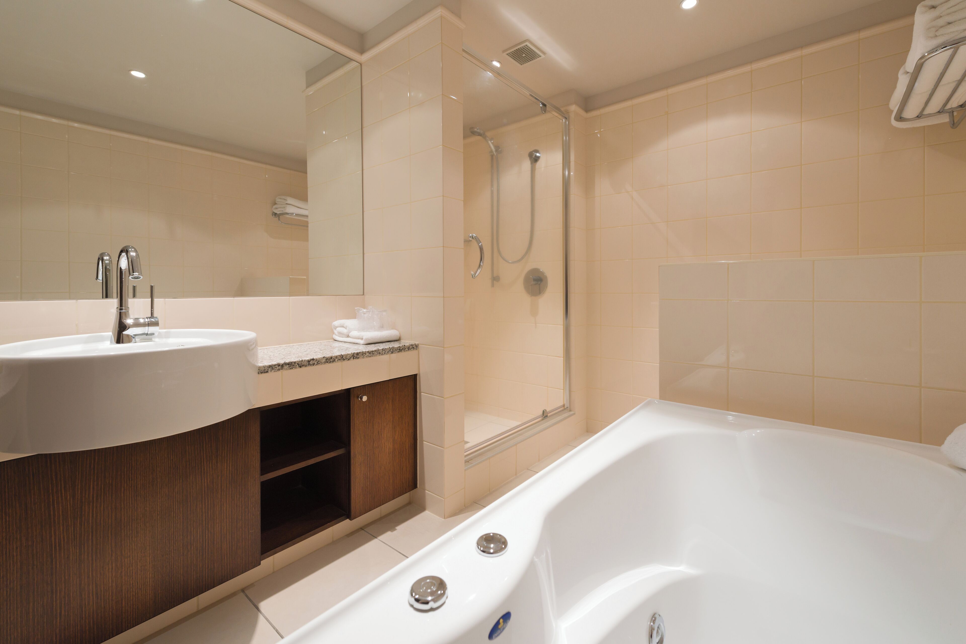 A modern bathroom with a bathtub, shower, and sink.