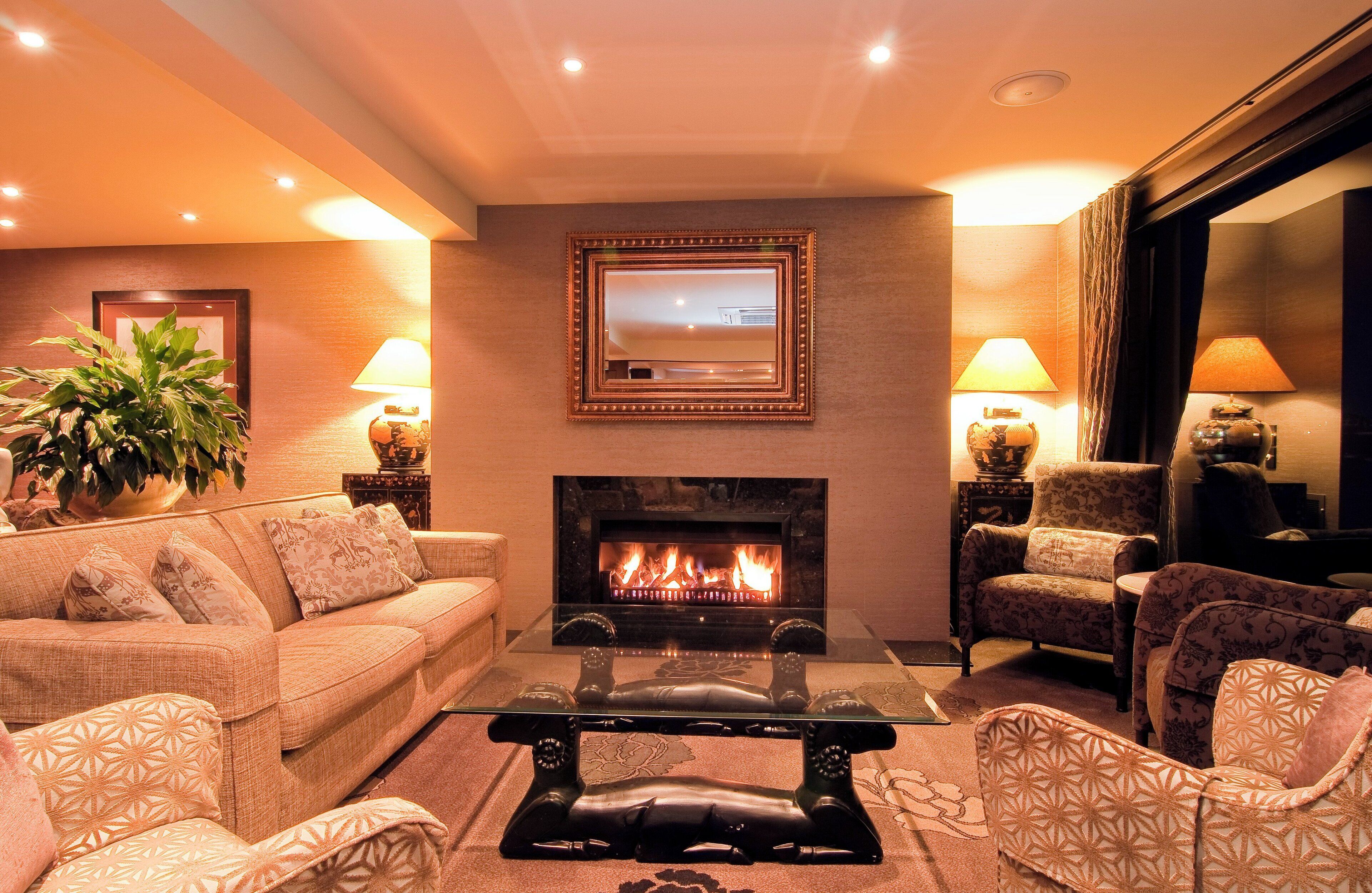 Una sala de estar con chimenea, un sofá, sillones y una mesa de centro.