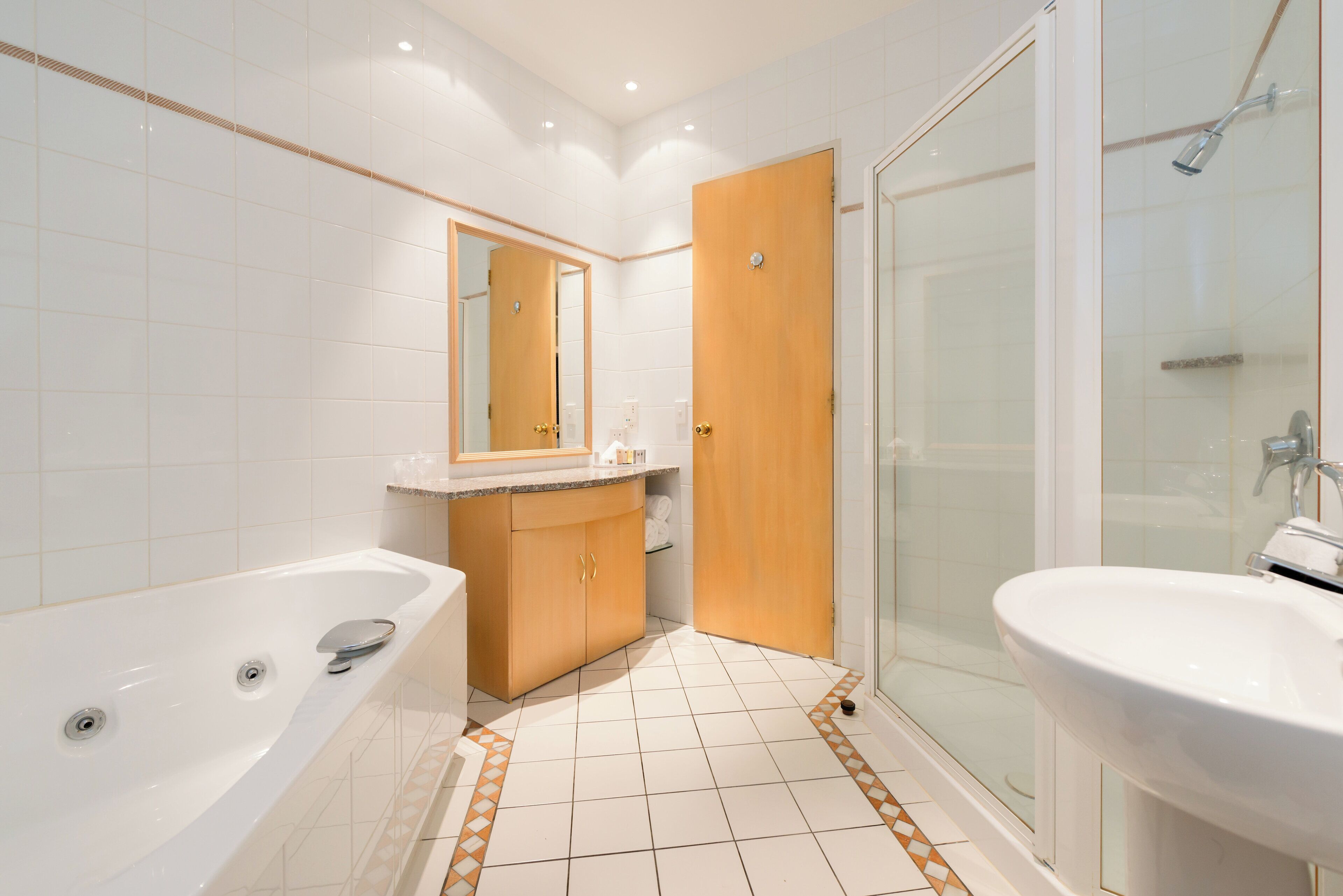 A modern bathroom with a bathtub, a sink, and a shower area.