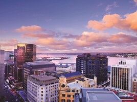 A cityscape with modern buildings, a waterfront, and a clear sky.