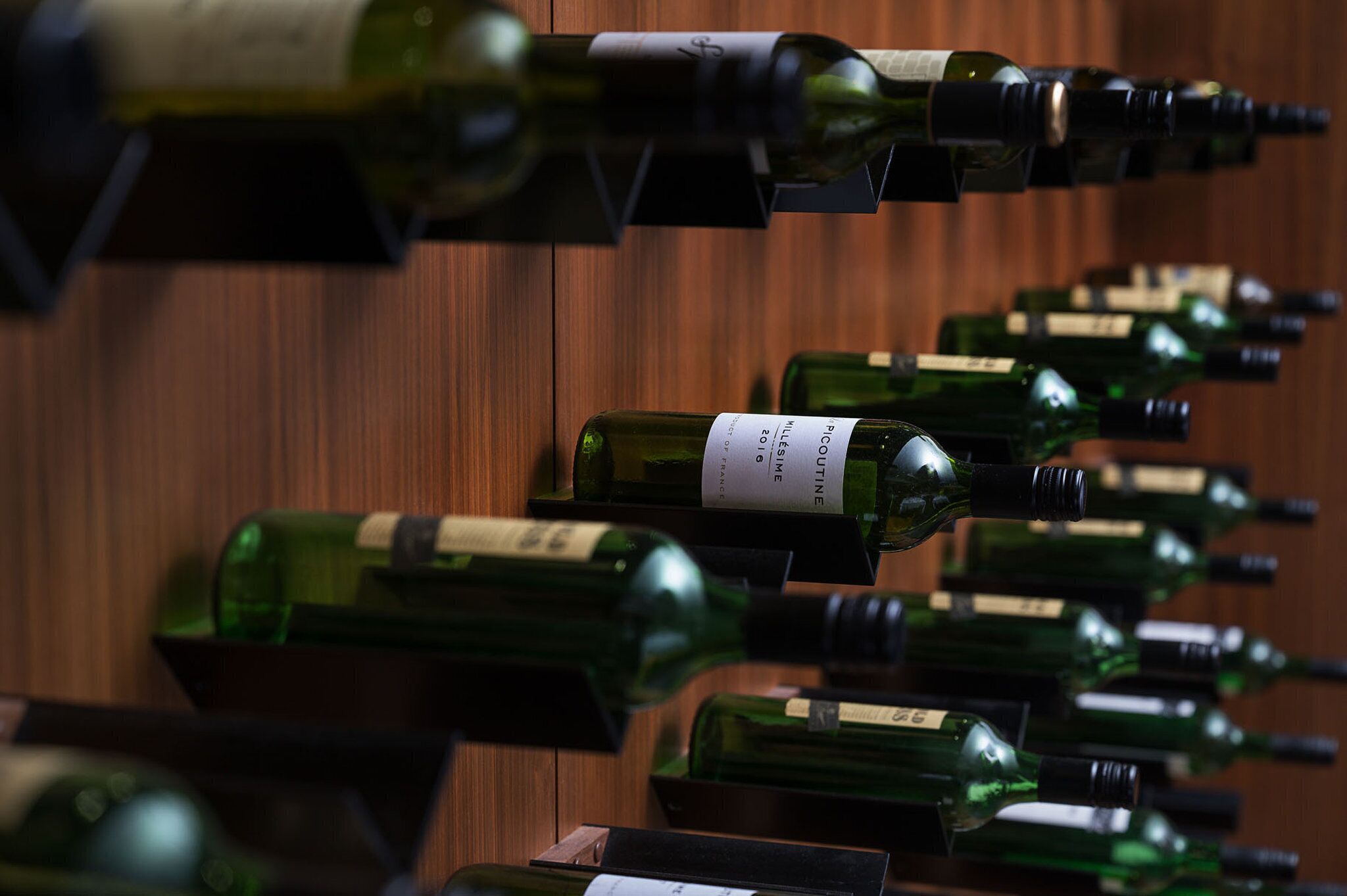 A collection of wine bottles arranged in a wooden rack.