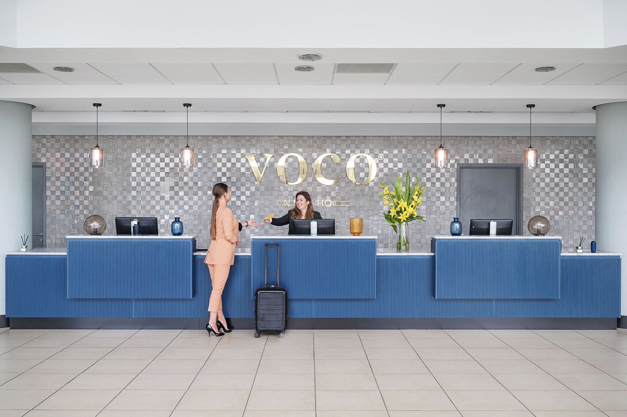 A hotel reception desk with a check-in counter, a digital display, and a reception area.