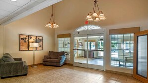 A spacious lobby with two sofas, a floor lamp, and a large world map artwork. - Extended Stay America Suites Lancaster County (Mountville)