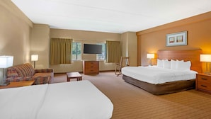 A hotel room with a large bed, a smaller bed, a sofa, a desk, and a TV. - Extended Stay America Suites Lancaster County (Mountville)