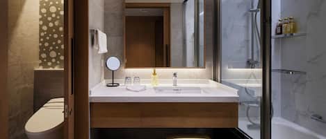 Un baño moderno con inodoro, lavabo, espejo y ducha.