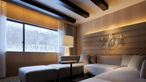 A modern hotel room with a sofa, ottoman, and a small table. - Niseko Northern Resort An'nupuri (Niseko)