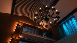 A modern interior with a large chandelier, a balcony, and a view of the sky through a window. - Niseko Northern Resort An'nupuri (Niseko)