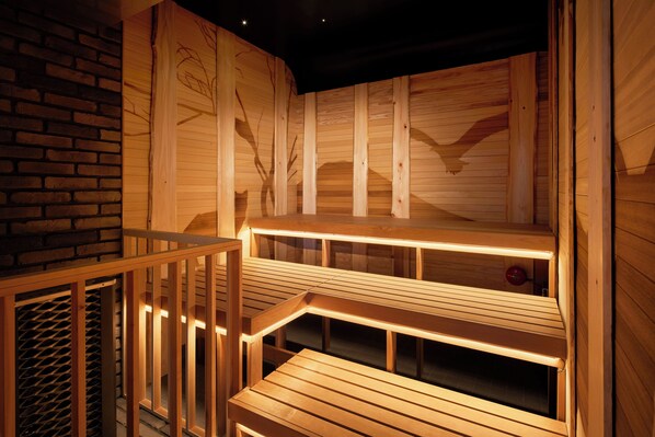 A wooden sauna with multiple benches and a glass enclosure.