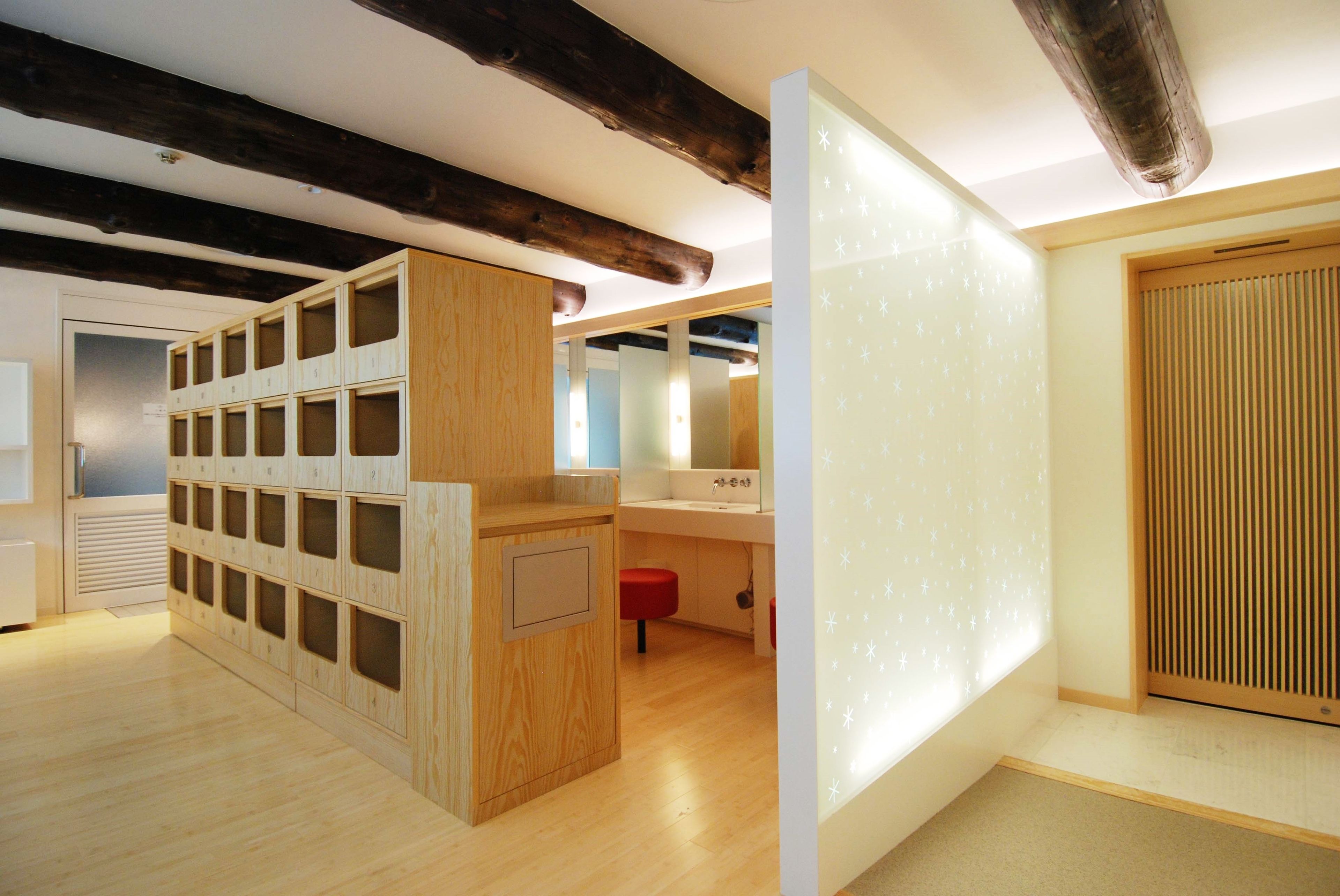 A modern bathroom with wooden cabinets, a mirror, and a toilet.