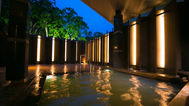 A heated outdoor pool area with wooden railings and a covered walkway. - Niseko Northern Resort An'nupuri (Niseko)