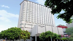 A modern hotel building with a prominent entrance and multiple flags. - Hotel du Parc Hanoi (Hanoi)