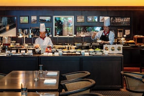 A buffet setup with multiple food stations and a chef preparing food. - Hotel du Parc Hanoi (Hanoi)