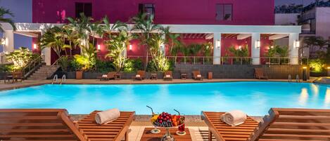 Een buitenzwembad, parasols voor strand/zwembad