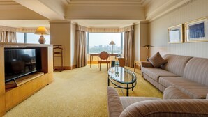 A hotel room with a TV, sofa, armchair, and a desk with a lamp. - Hotel du Parc Hanoi (Hanoi)