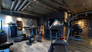 A gym with treadmills, elliptical machines, and weight machines. - pentahotel Kassel (Kassel)