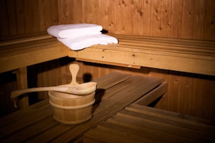 A wooden sauna bench with a towel and a wooden ladle.
