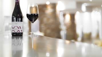 Eine Weinflasche und ein Glas auf einer spiegelnden Oberfläche.