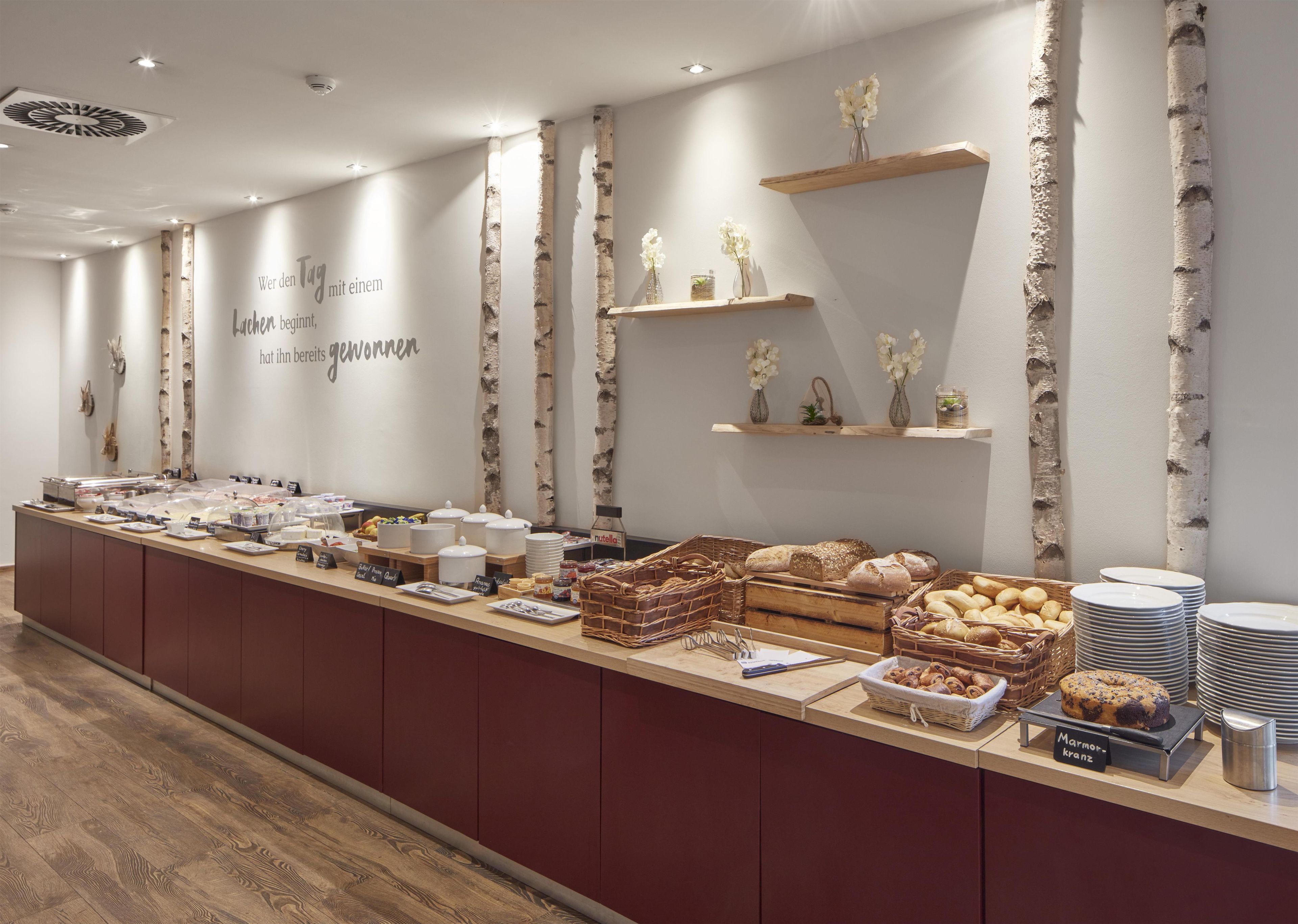 Disposição de buffet com diversos alimentos e um aviso indicando opção de café da manhã.
