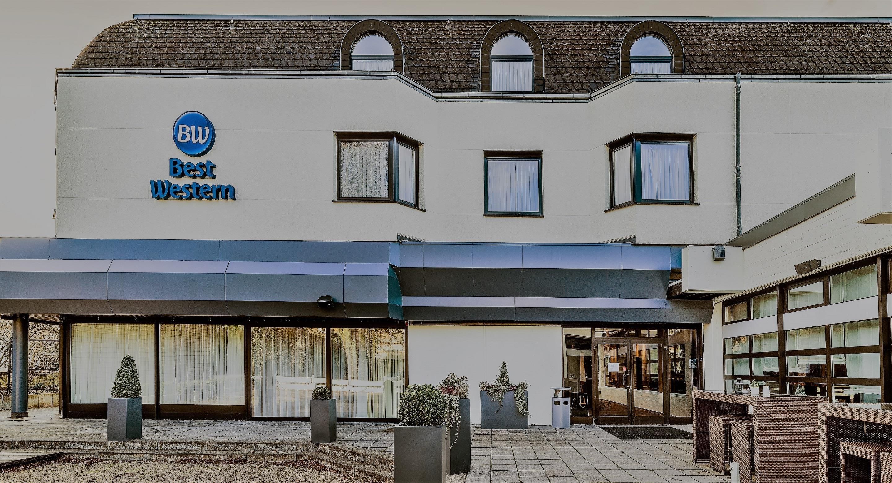 Ein Hotel mit einem Schild mit der Aufschrift 'BW Best Western' und einem überdachten Eingangsbereich.