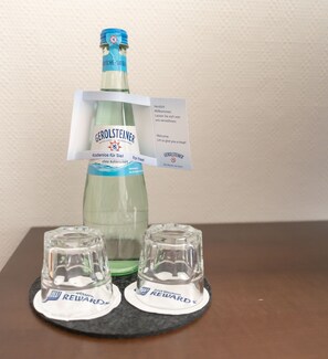 En Gerolsteiner vandflaske med blå låg og en anbragt etiket.