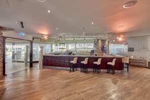 A bar area with wooden flooring, a reception desk, and bar stools. - Best Western Hotel Trier City (Trier)