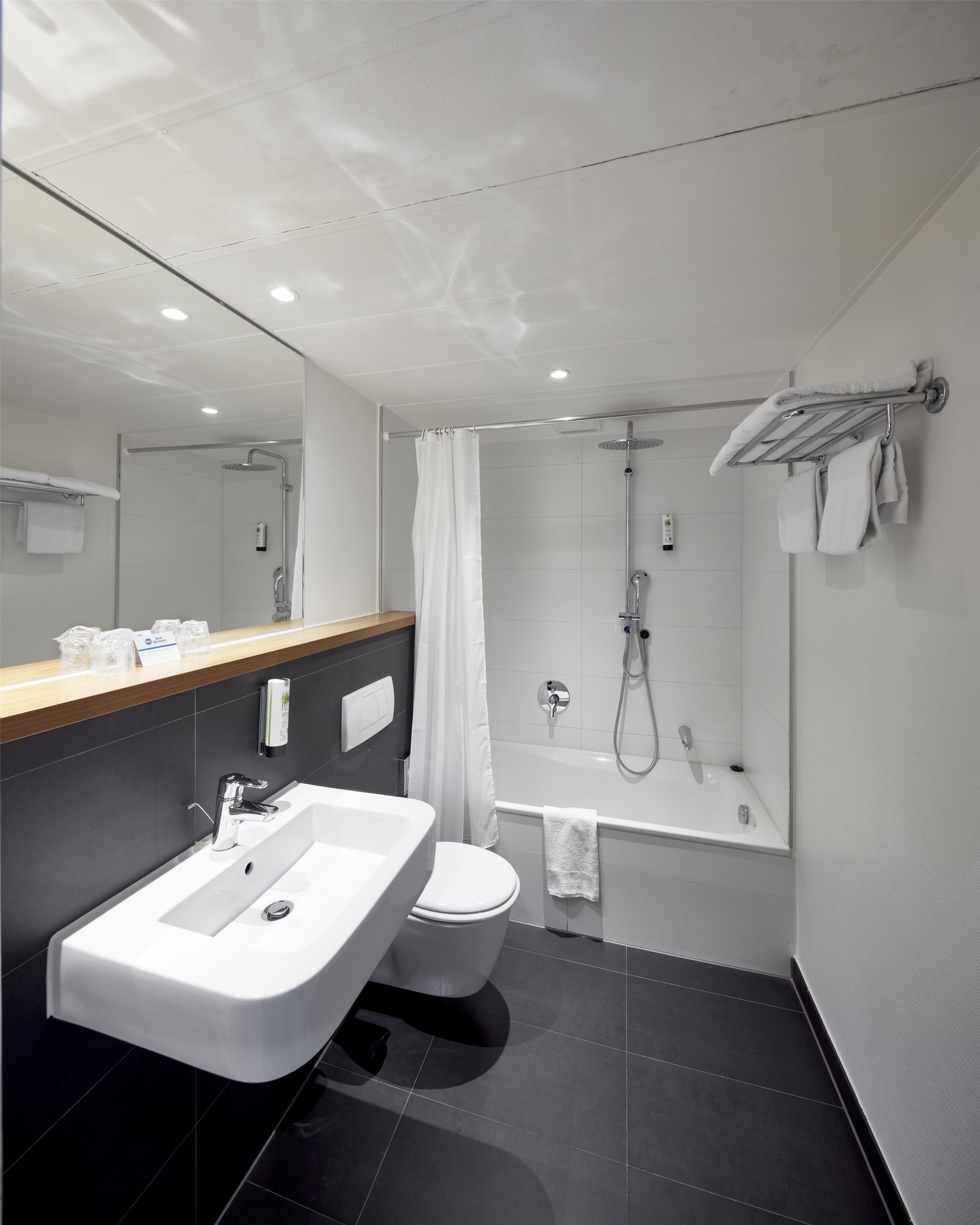 Un baño moderno con lavamanos, inodoro, ducha y bañera.