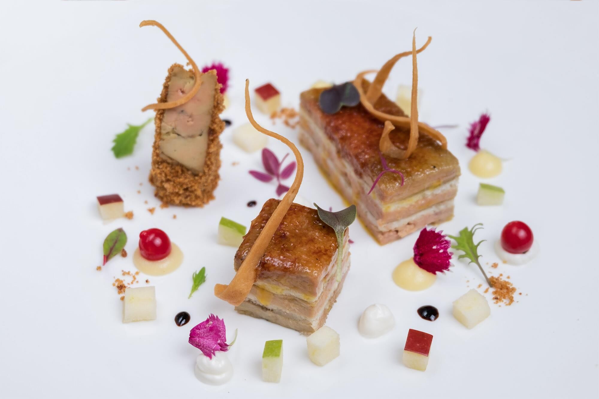 A dessert plate with layered cake and fruit garnishes.