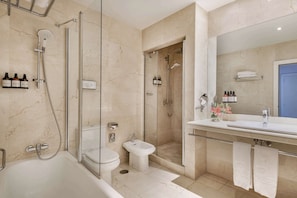 A modern bathroom with a bathtub, toilet, bidet, and walk-in shower.