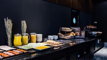 Buffet amb diferents aliments, com ara carns, pa i suc.