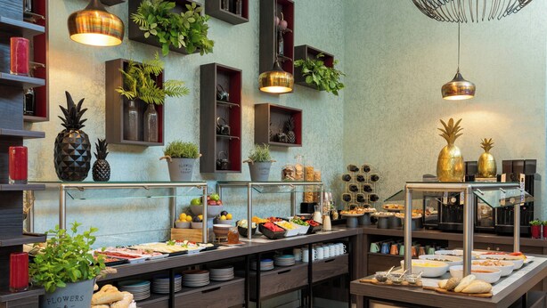 Een buffet met diverse gerechten en planten.