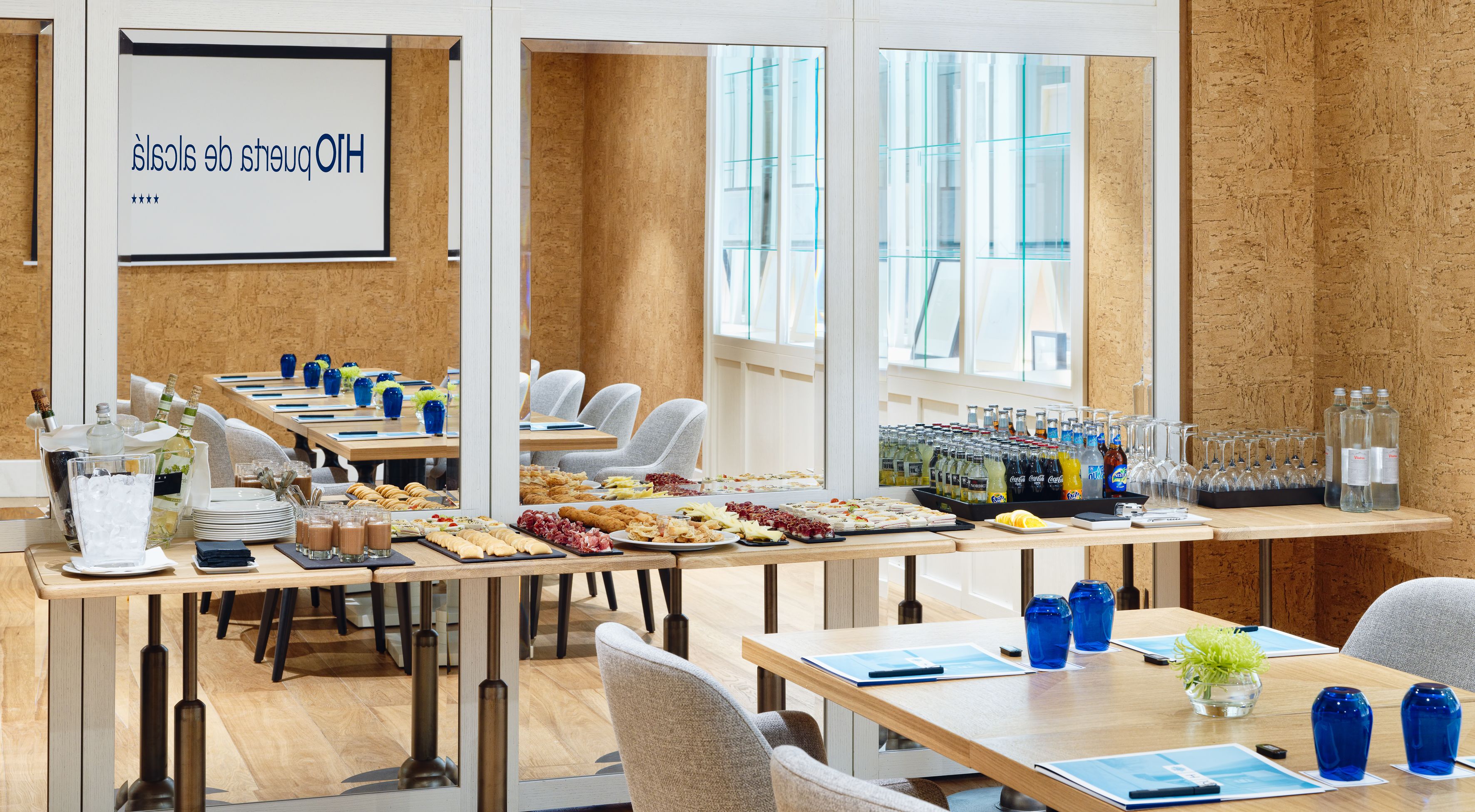 A conference room with long tables, catering service, and a projection screen.