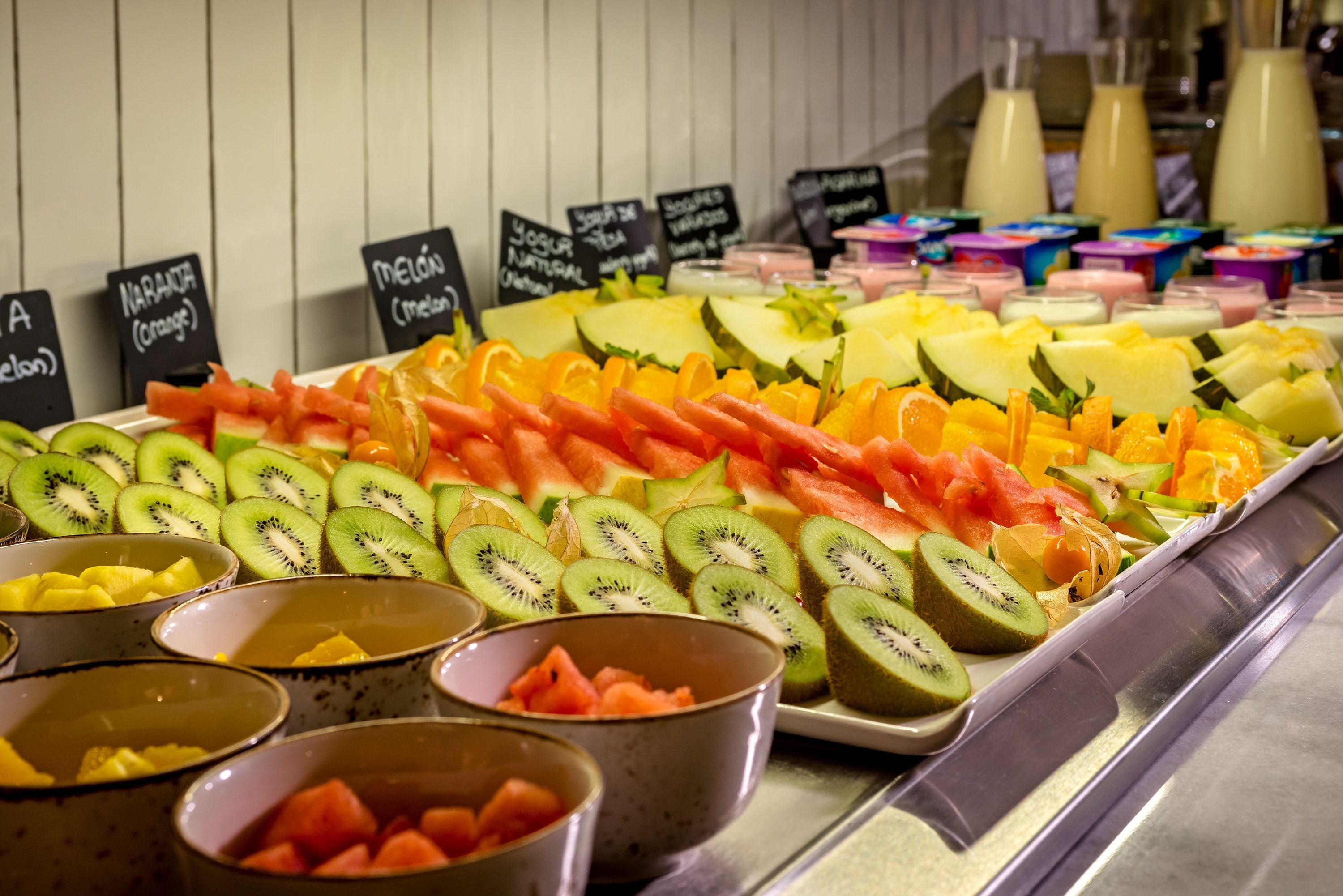 Verschiedene frische Früchte und Joghurts werden in einer Kühlvitrine präsentiert.