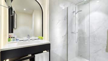 Une salle de bain moderne avec un meuble-lavabo en marbre, un grand miroir et une douche à parois de verre.