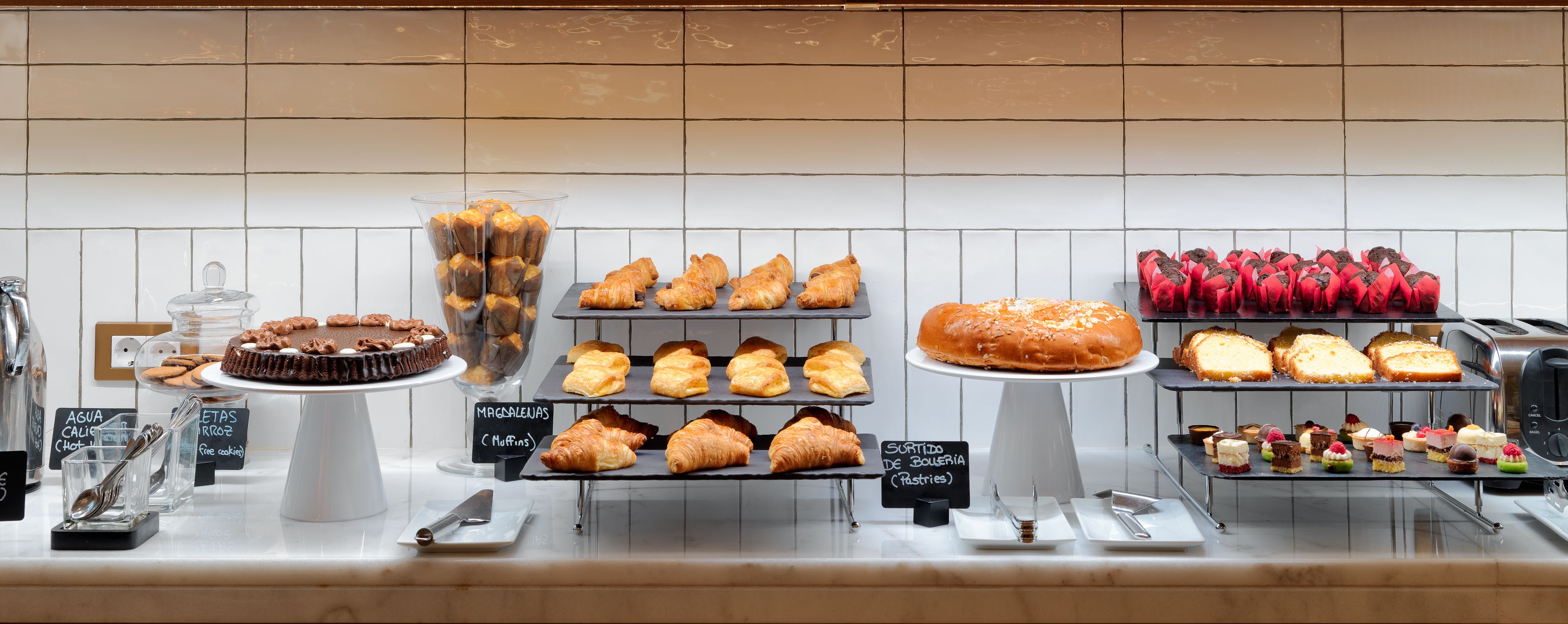 Mostrador de pastelería con diversos pasteles y postres.
