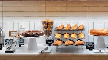 Mostrador de pastelería con diversos pasteles y postres.
