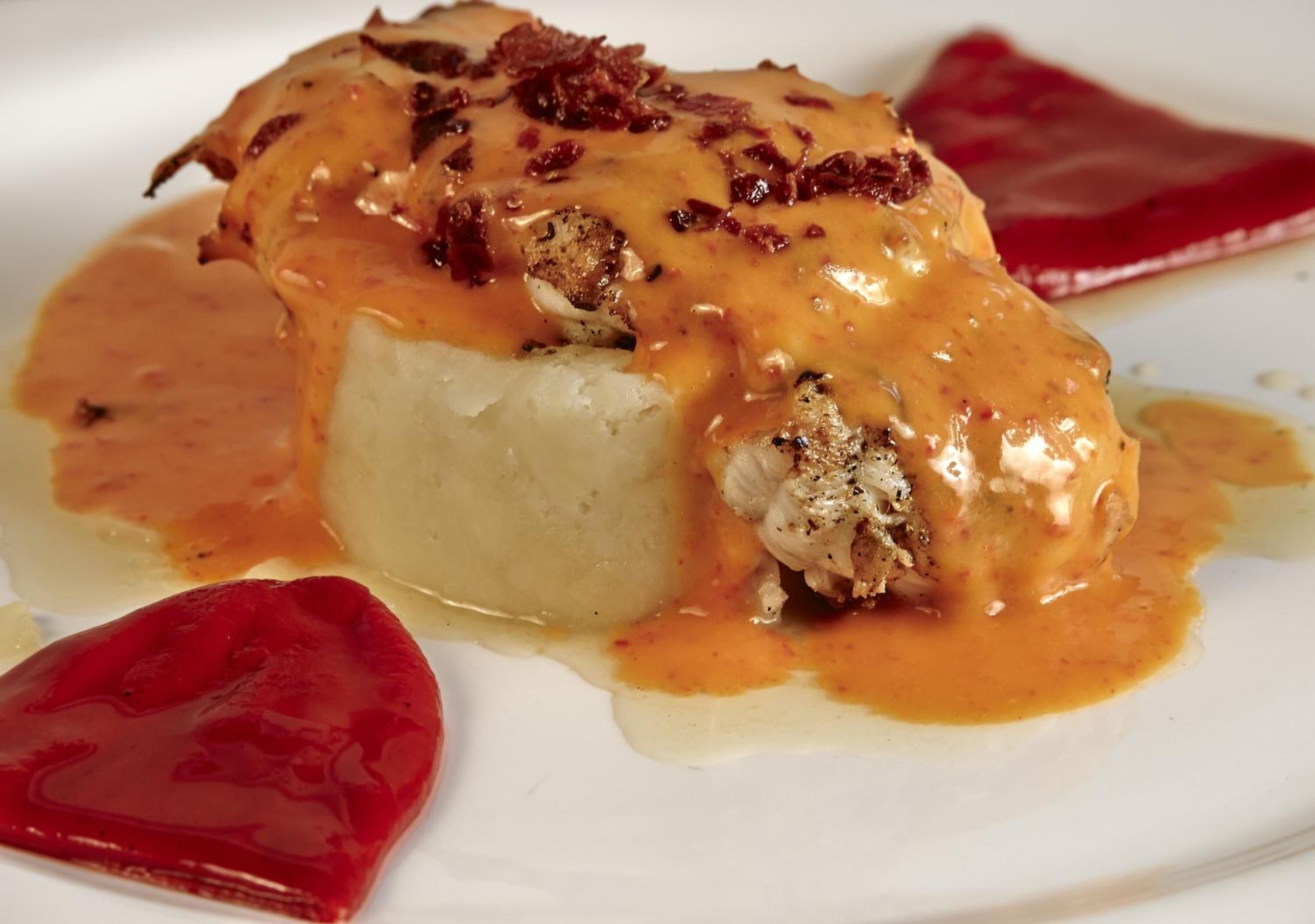A dish with a creamy sauce and crispy topping, served on a white plate.