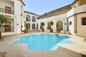 Una piscina al aire libre, sillones reclinables de piscina