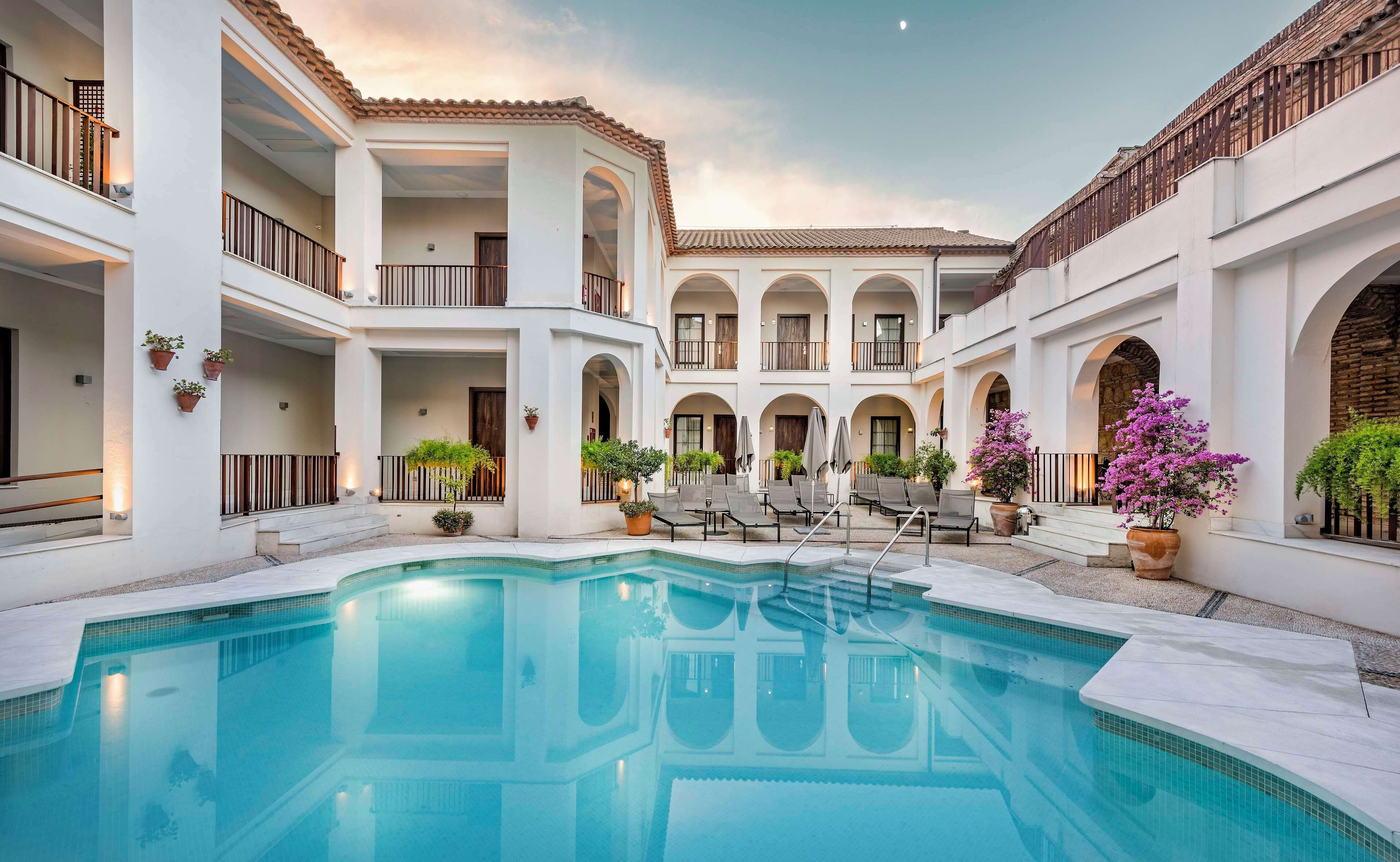 Een buitenzwembad, ligstoelen bij het zwembad