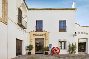 Un bâtiment sur lequel on peut lire l’inscription « H COLLECTION » et devant lequel se trouve une grande pièce décorative rouge.
