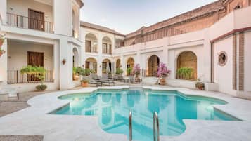 Una piscina al aire libre, tumbonas