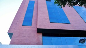 Un edificio con fachada de ladrillo rosa y grandes ventanales azules.