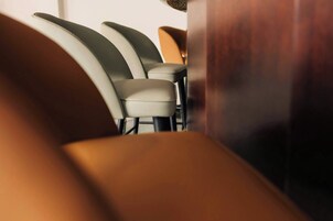 Unos sillones en fila con una mesa de madera en el centro, sugiriendo una disposición de asientos en un restaurante o cafetería.
