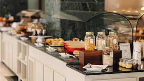 Un mostrador de buffet con diversos alimentos y recipientes.
