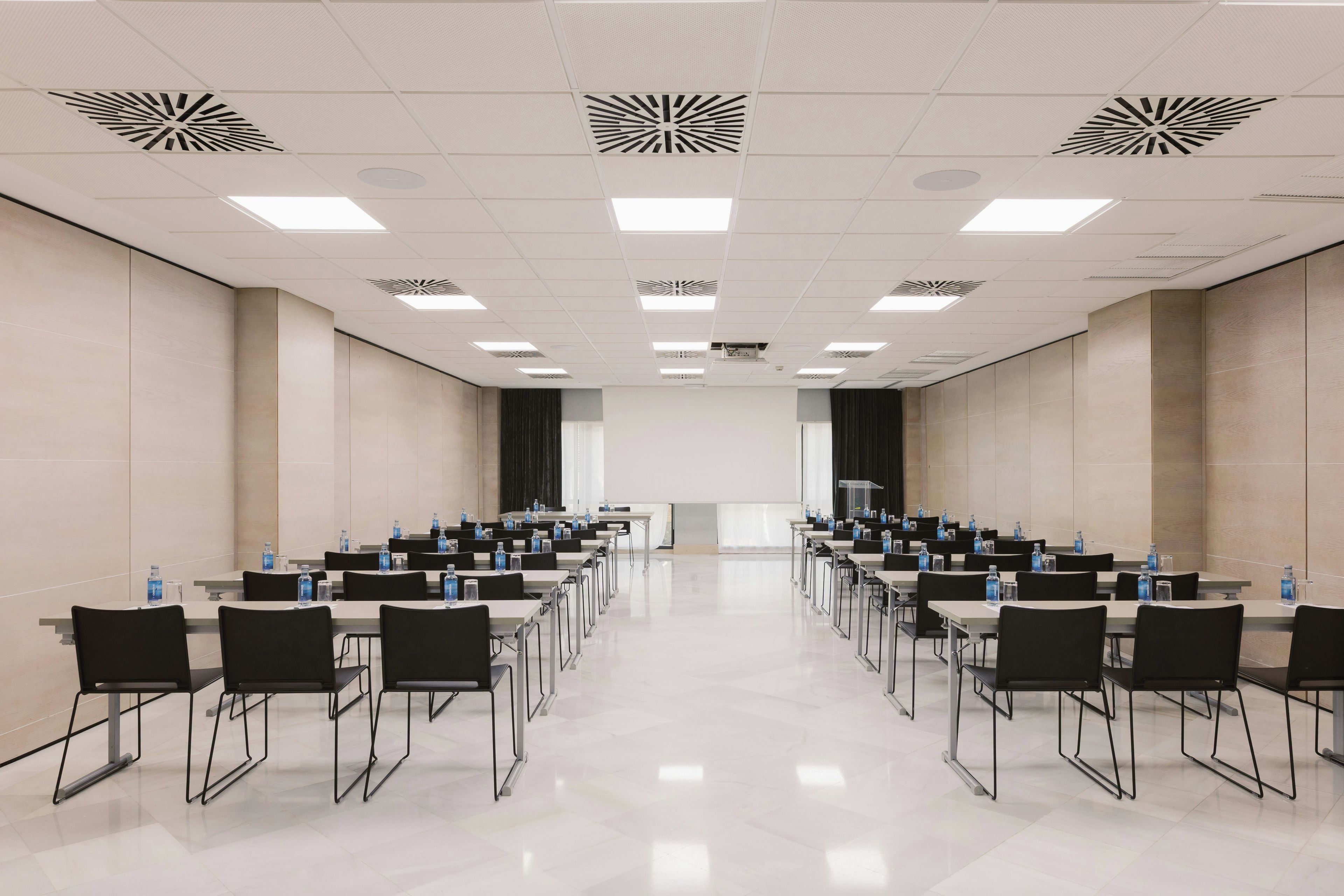 A conference room with a long table, chairs, and water bottles.