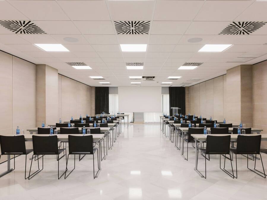 A conference room with a long table, chairs, and water bottles.