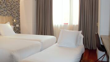 Una habitación de hotel con dos camas, un escritorio y una silla.