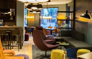 Un interior moderno con zona de comedor, asientos y un ventanal grande.