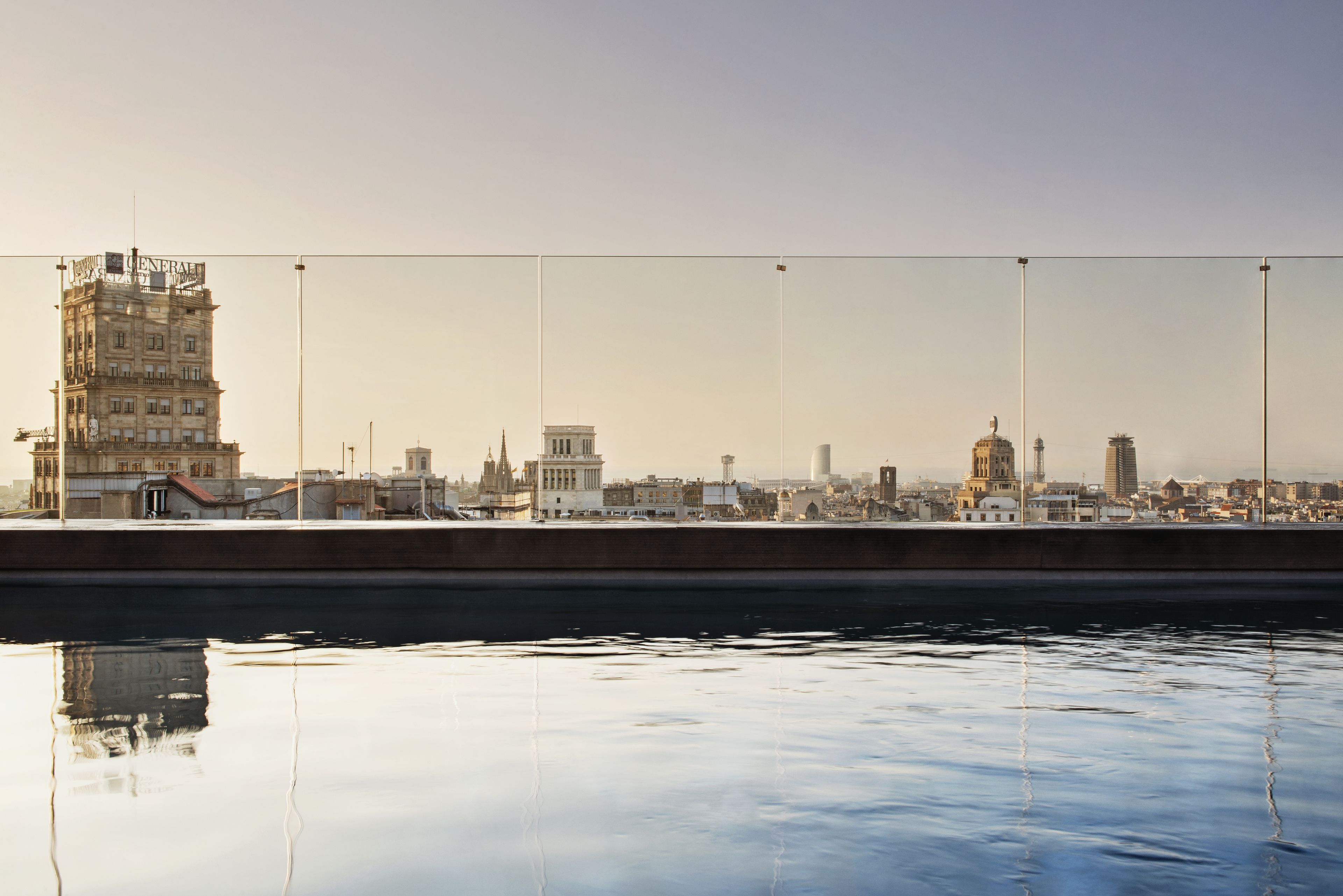 A waterfront view with a bridge, buildings, and a calm water body reflecting the structures.