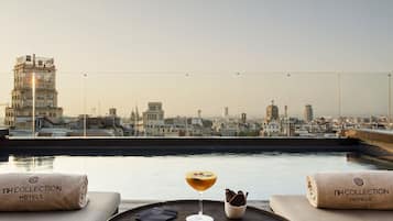 Alberca al aire libre, sombrillas en la alberca y camastros