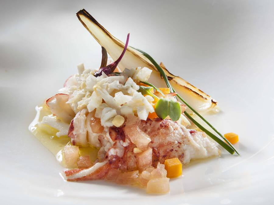 Prato com frutos do mar, legumes e um enfeite.